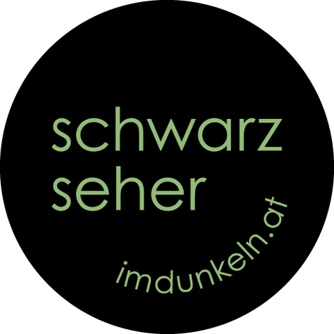 Runder schwarzer Button mit Aufdruck in grüner Schrift, Text: „schwarzseher“, „imdunkeln.at“